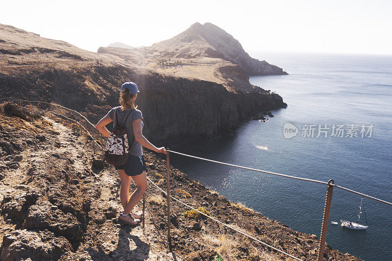 在葡萄牙马德拉岛，一个女人在Ponta de S?o Louren?o上享受日出